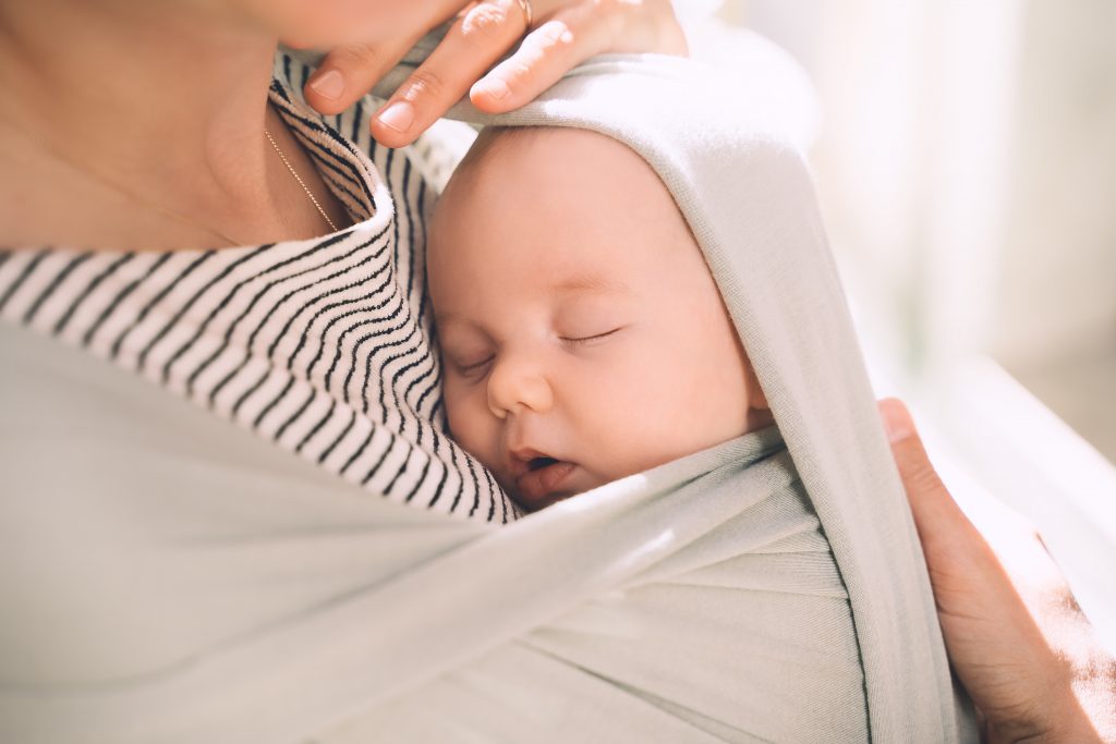 baby sleeping in a baby carrier